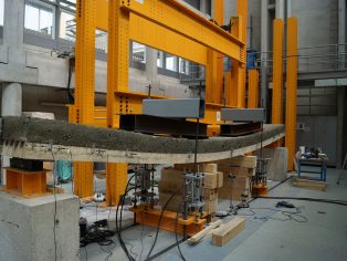 An 8 meter long timber and wood-cement composite slab is tested to rupture at the School of Engineering and Architecture Fribourg within a project of the National Research Programme 66 “Resource Wood”. Although weighing only a third of an equally performing regular concrete slab, this new type of composite could, in principle, be used in residential and office buildings.